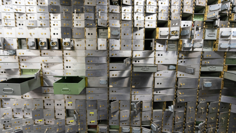 Artful photo of dozens of bank deposit drawers open to varying degrees of disarray