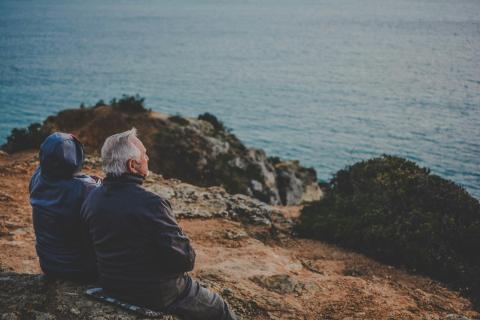 Old couple sitting by the sea