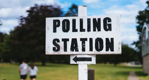 Painted polling station sign with arrow