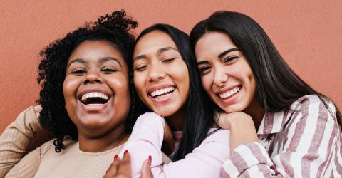 Happy women from multi-ethnic communities hugging each other
