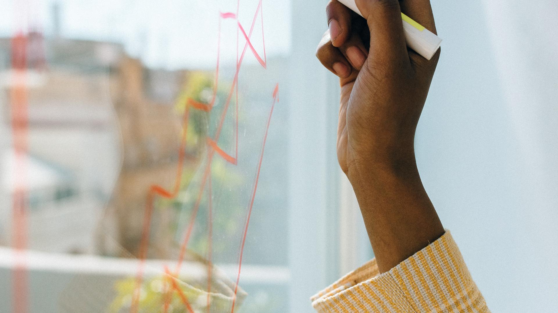 Person using whiteboard pen against a window to draw a diagram