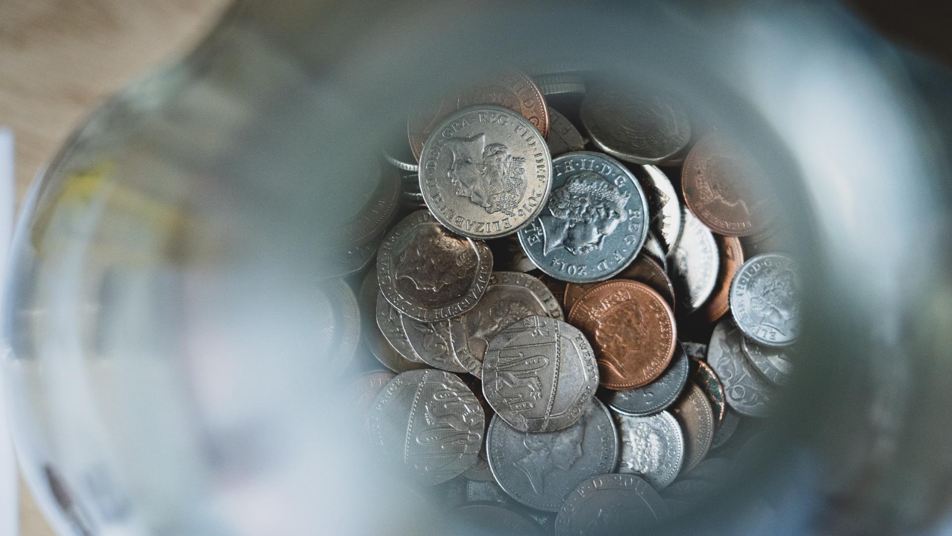 View from the top of a jar filled with UK currency coins