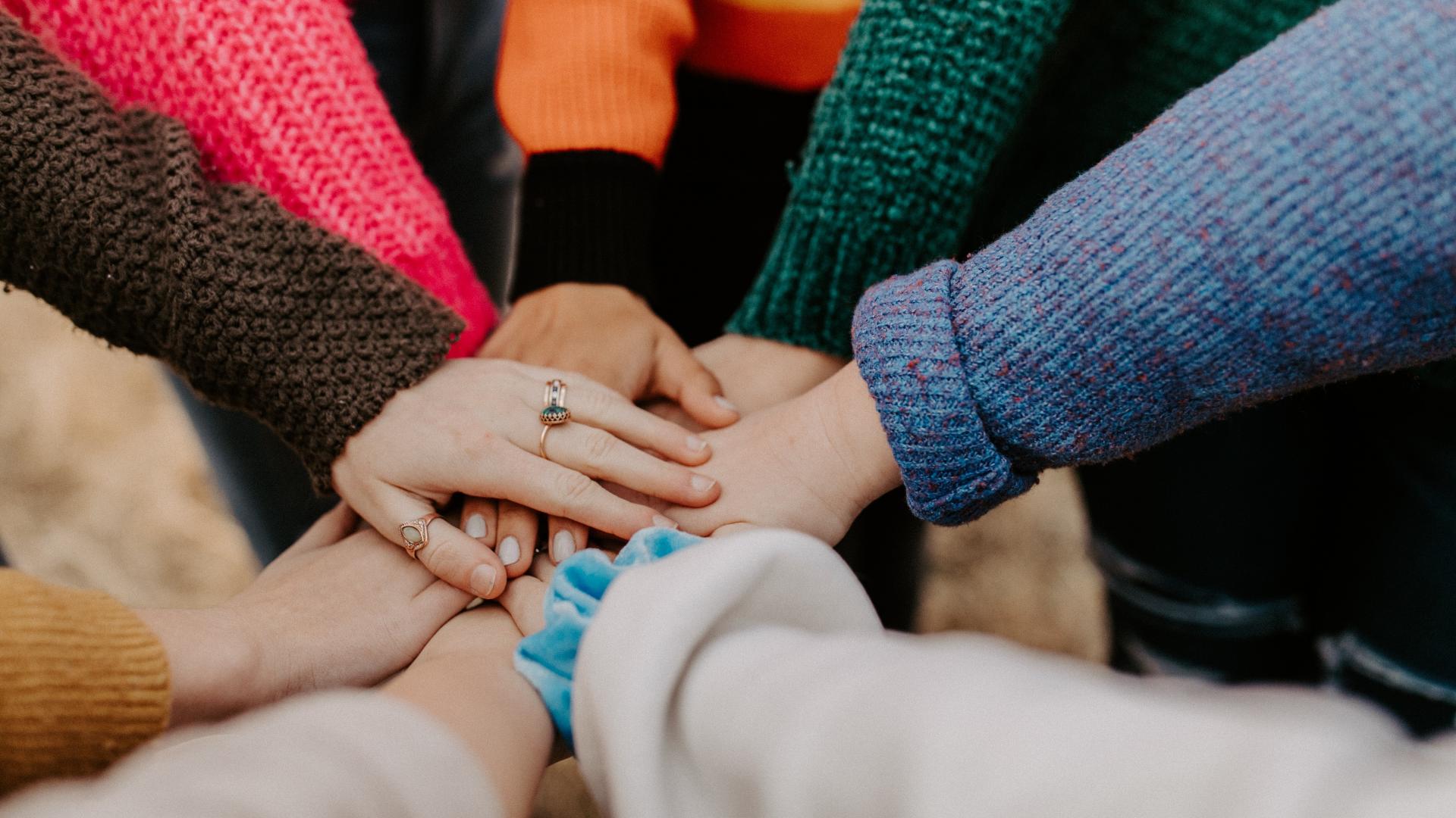 People putting their hands into the middle of their circle