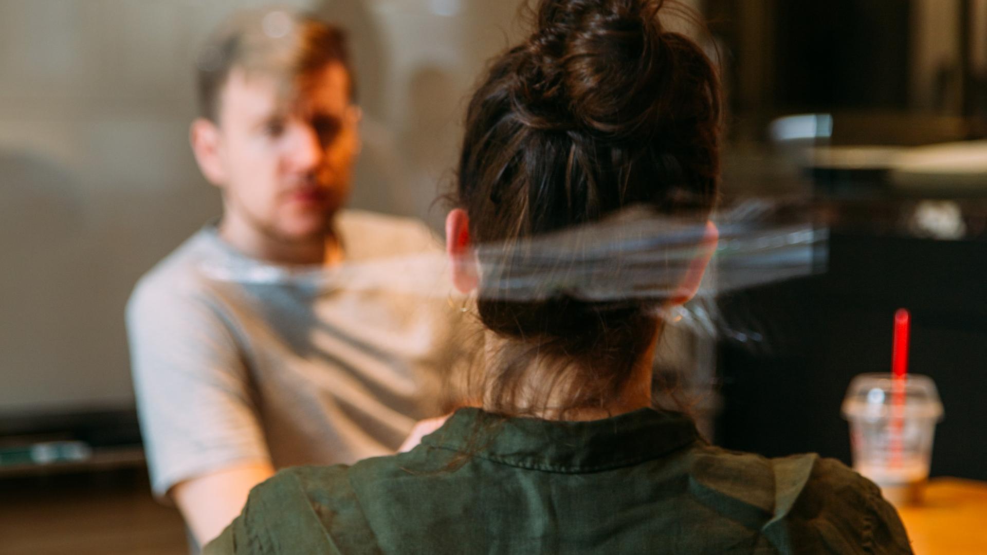 Image of people talking behind a glass screen