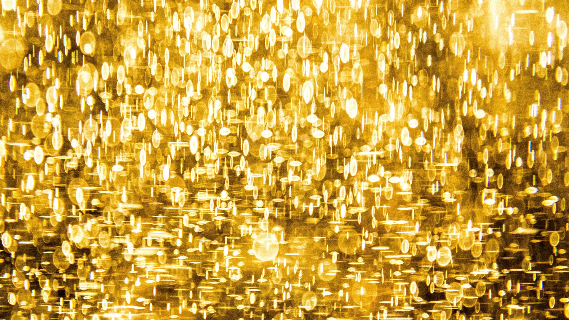 Gold glitter shining against a dark background