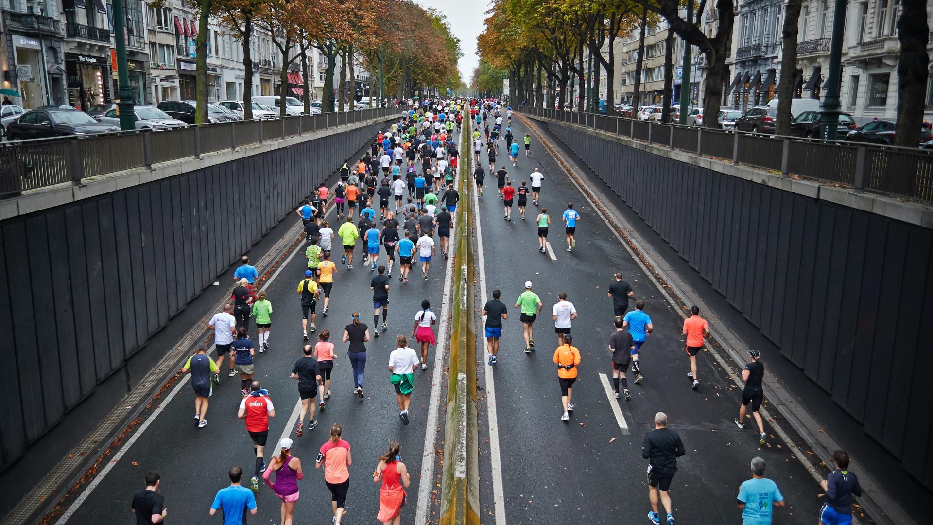 Marathon runners travel up a road