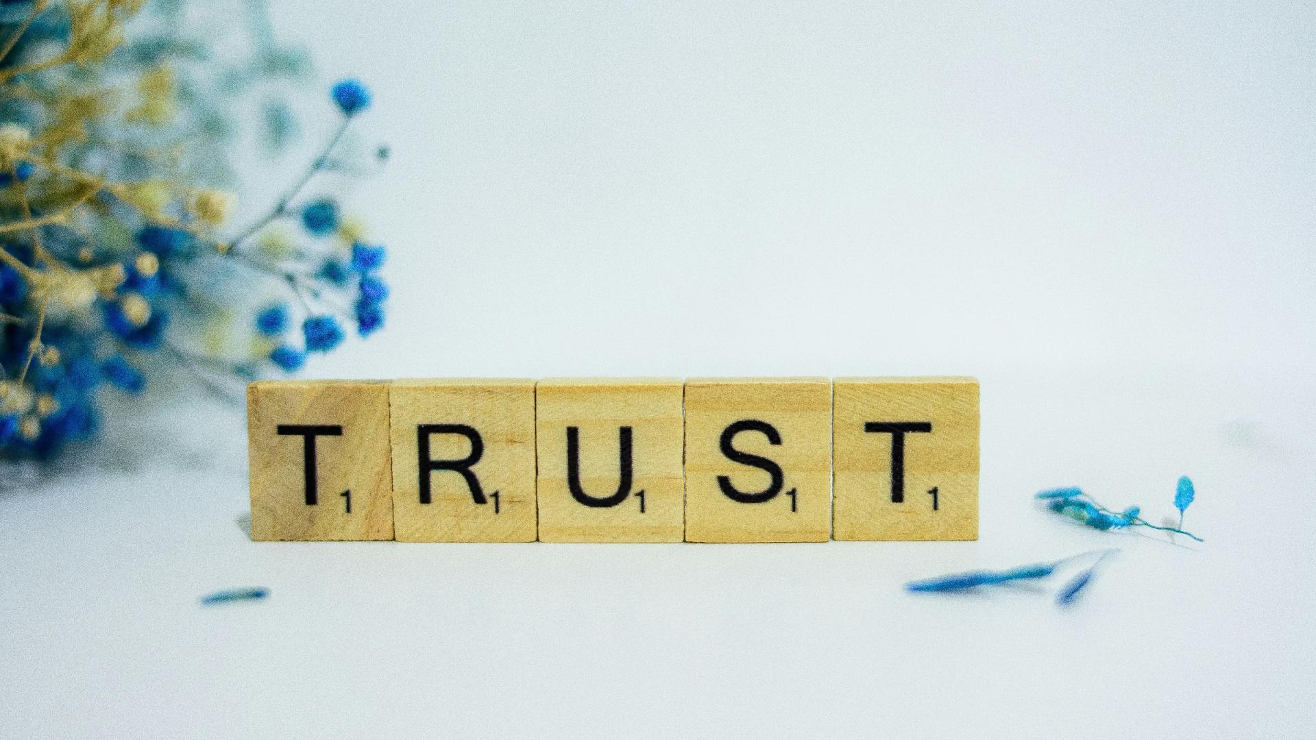 A photo of scrabble tiles spelling out the word trust