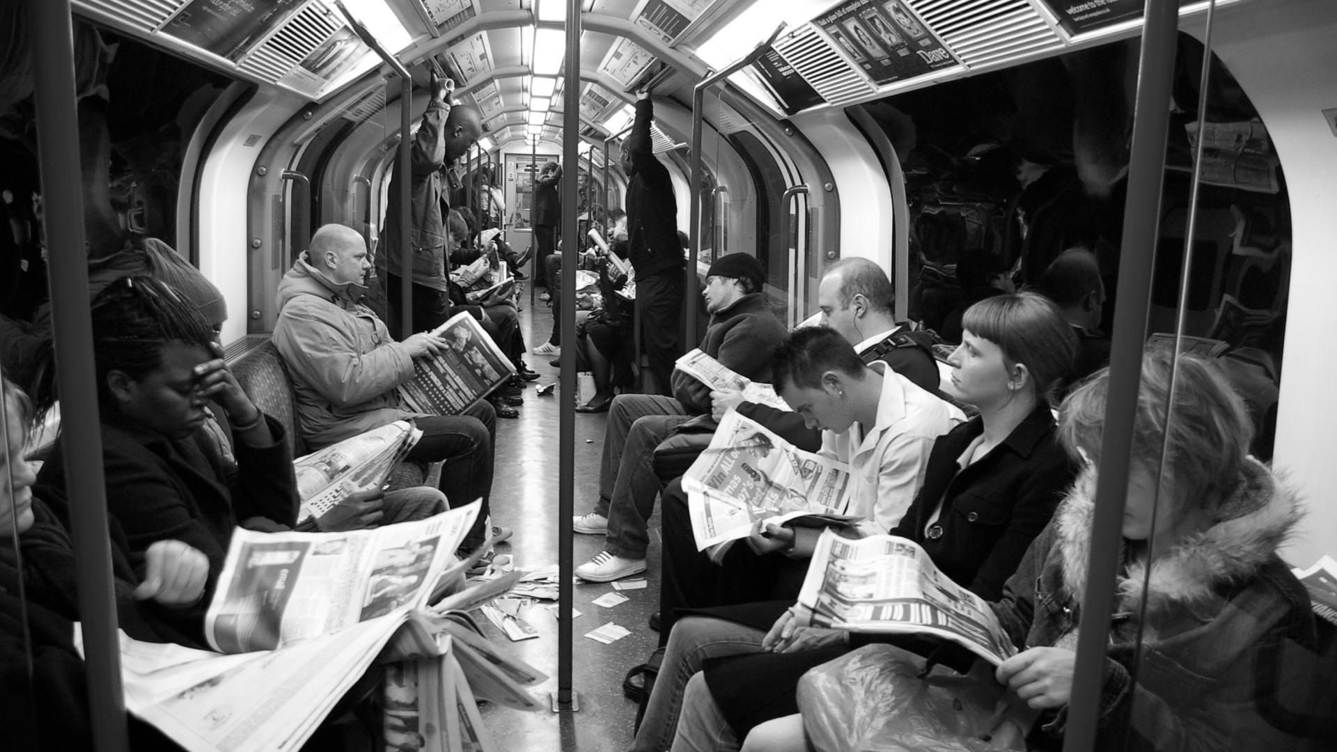 People reading newspapers on the London underground