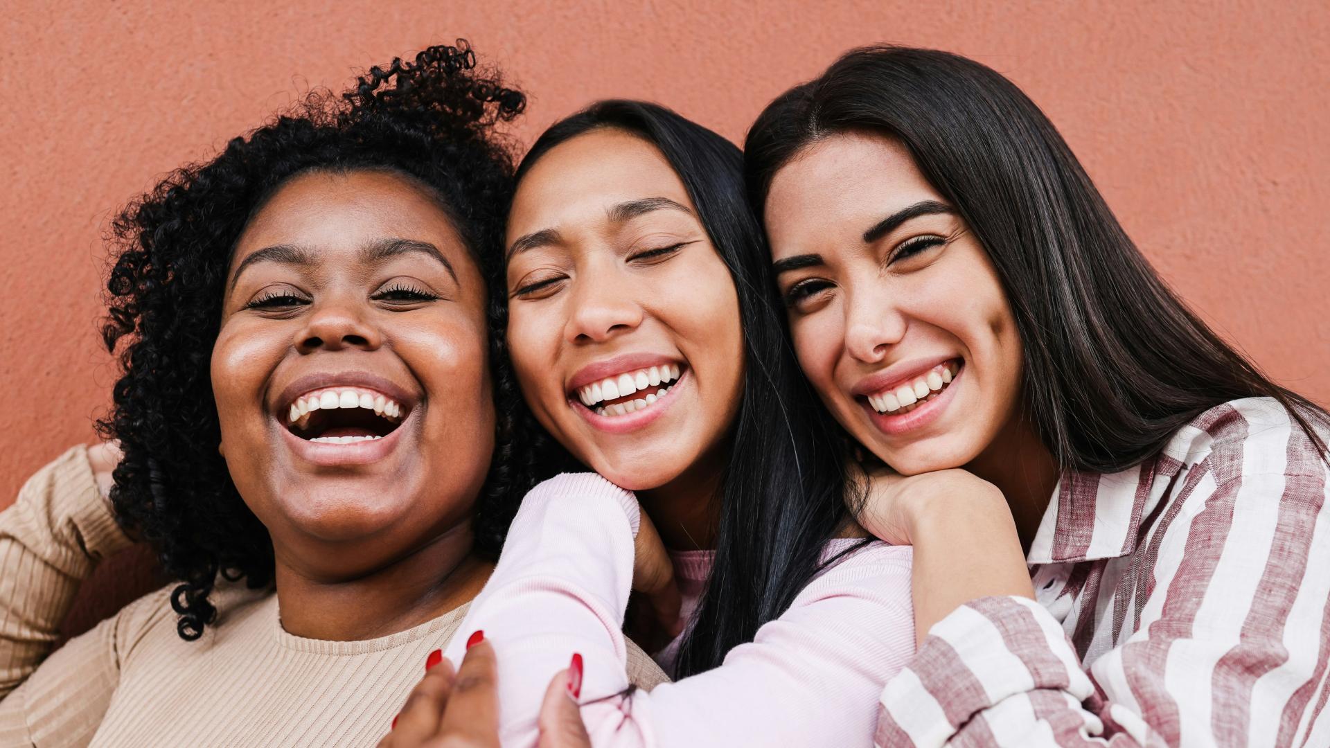 Happy women from multi-ethnic communities hugging each other